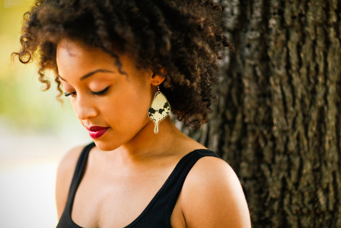 Model in golden light wearing real butterfly wing earrings